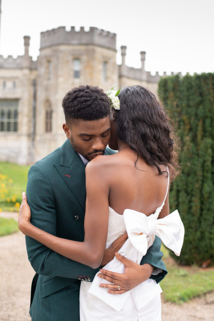 multicultural groom kissing brides shoulder